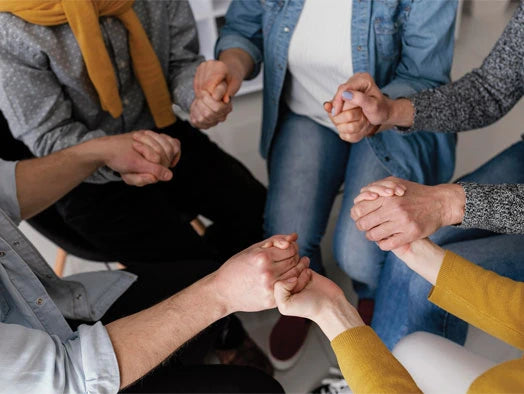 People holding hands in prayer, symbolizing church unity